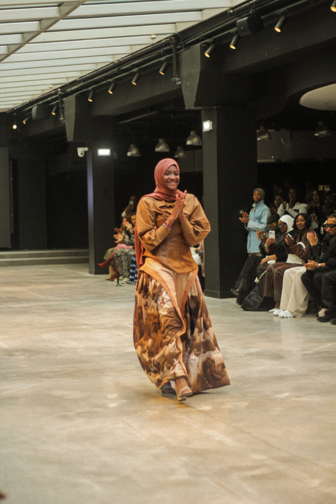 Madina Tangara, founder and creative director of NAANIYA, walking the runway in a printed gown at Paris Fashion Week