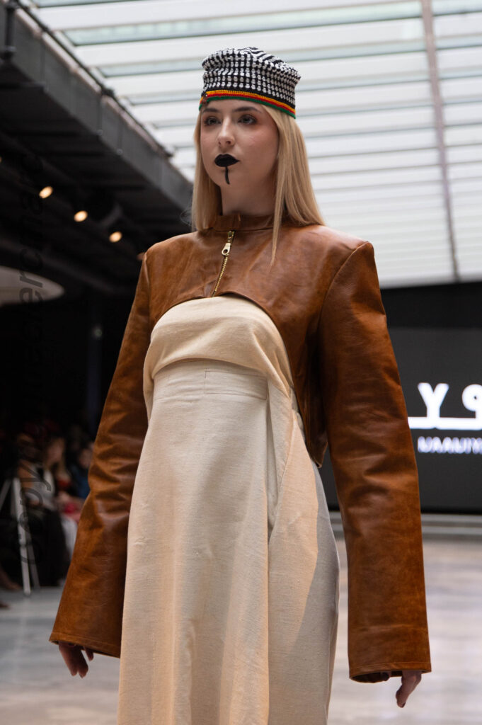 Model in a tan leather jacket over a cream bustier and skirt, NAANIYA SS26 Tombouctou collection at Paris Fashion Week