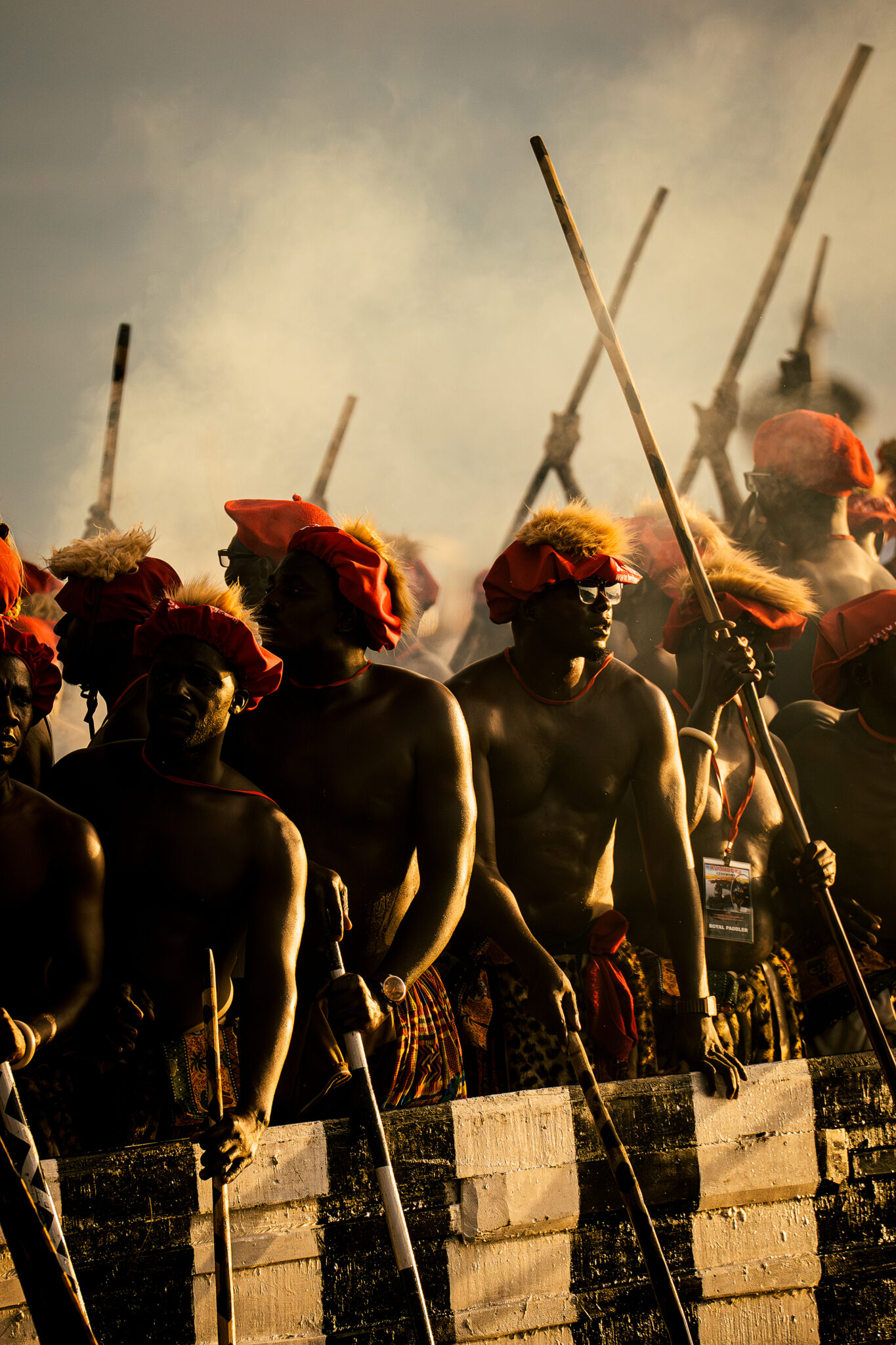 Six Days on the Zambezi: A Traveller's Guide to Kuomboka 5 Royal paddlers in red berets and fur headdresses hold their poles upright before the Nalikwanda departs at the Kuomboka ceremony in Zambia.