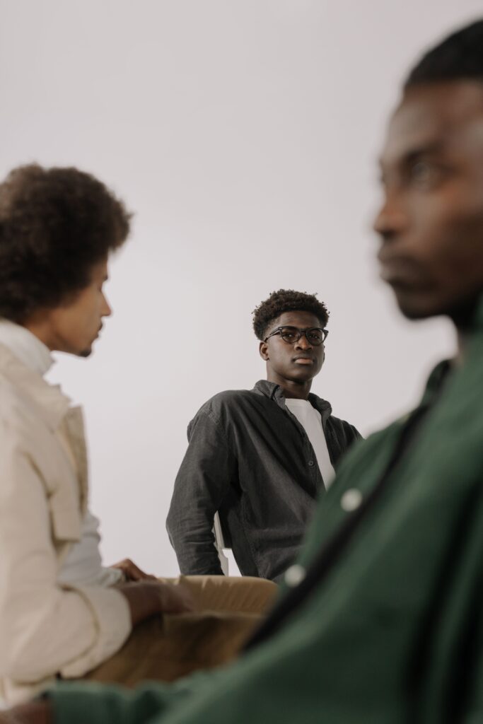 The Burden of Silence: Why African Men Struggle to Talk About Mental Health 2 A man sitting with his head lowered and hands clasped, conveying emotional weight.
