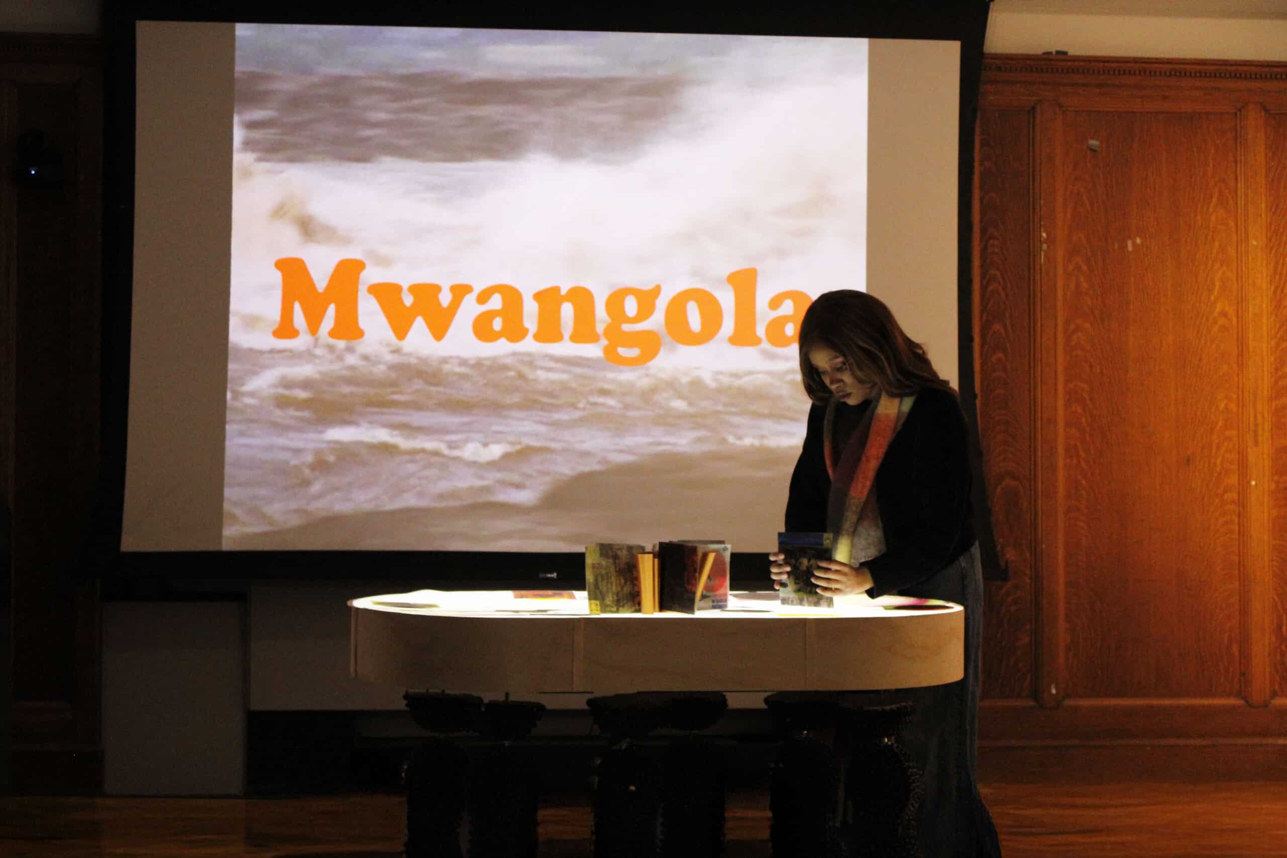 In Mwangola, Gelmira Gourgel Exhibits the Music That Fueled Angola's Independence 7 Gelmira Gourgel presenting the Mwangola exhibition on Angolan revolutionary music, standing beside archival records at Columbia University