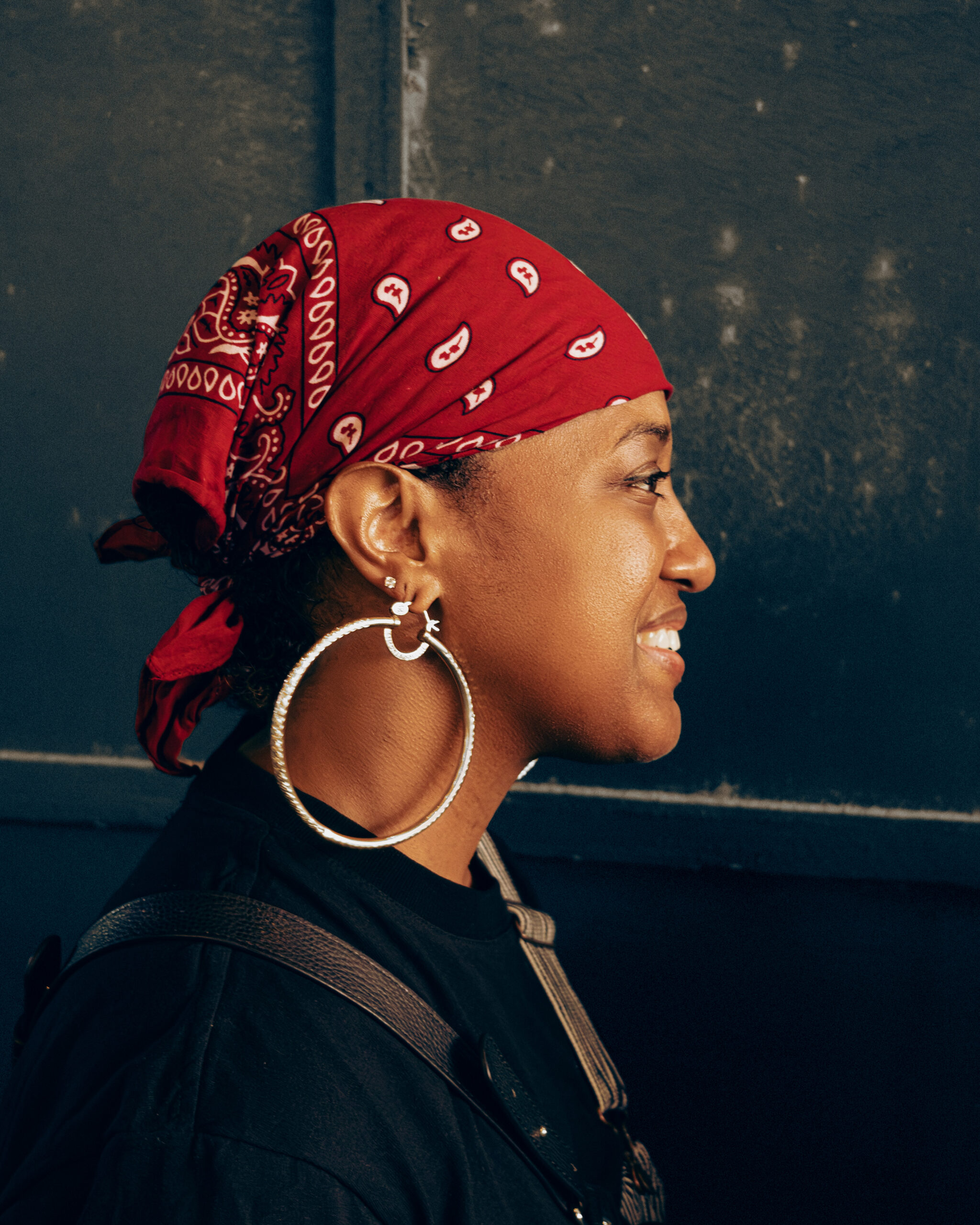 Before the Album, Rapsody Went to Ghana 2 A profile portrait of Rapsody wearing a patterned headscarf and large hoop earrings during her trip to Ghana
