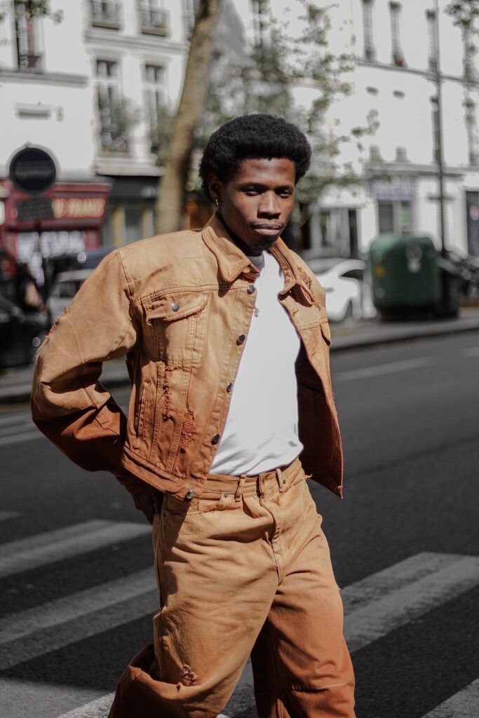 Celebrating Roots and Defying Borders: The Journey of Bledard - African Denim Revolution 3 A model in a tan workwear jacket and trousers standing on a Paris street