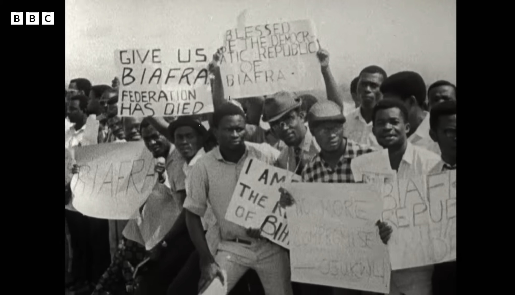 Demonstrators holding hand-lettered placards reading Give Us Biafra and Federation Has Died, in BBC archive footage of the 1967 push for secession in eastern Nigeria.
