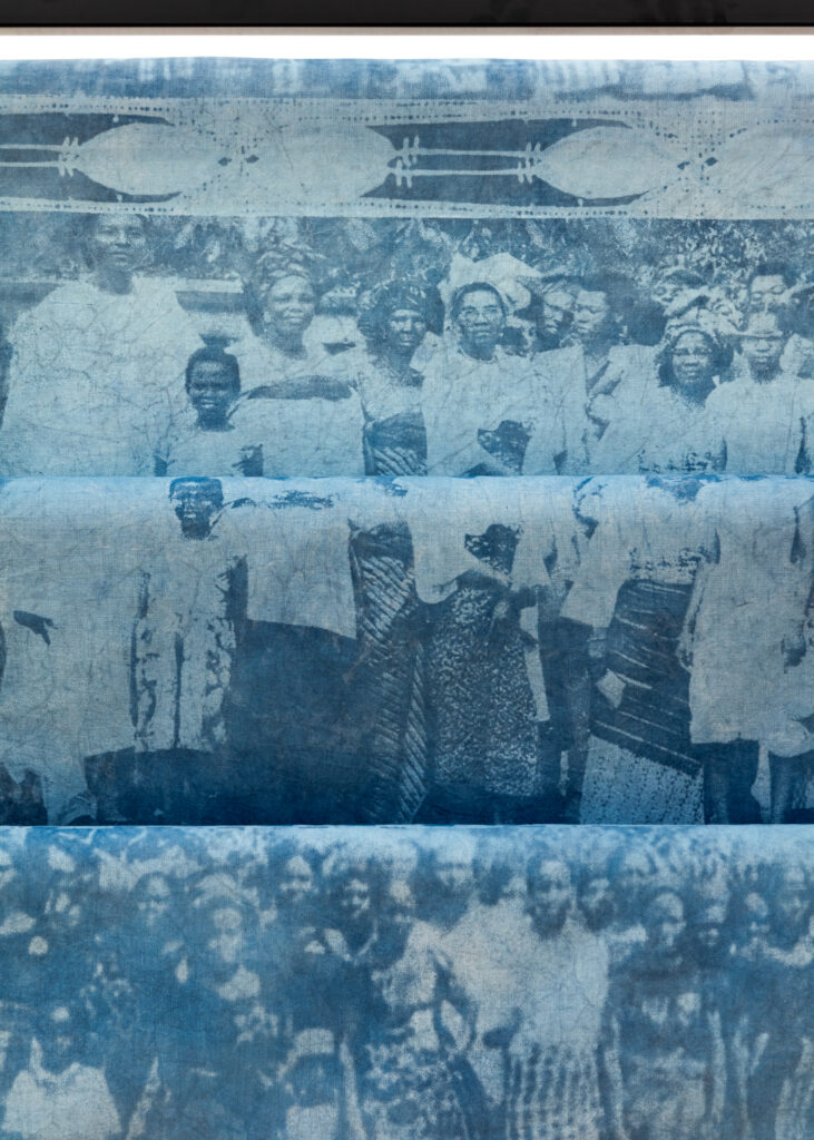 Adirẹ and the Wrapper-Wearers 7 Detail of indigo cloth showing banded rows of archival group portraits of women in wrappers and head ties, edged with resist-dyed borders.