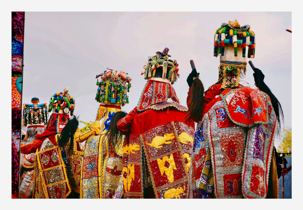 Rear view of the procession showing carved wooden superstructures crowded with figures and animals