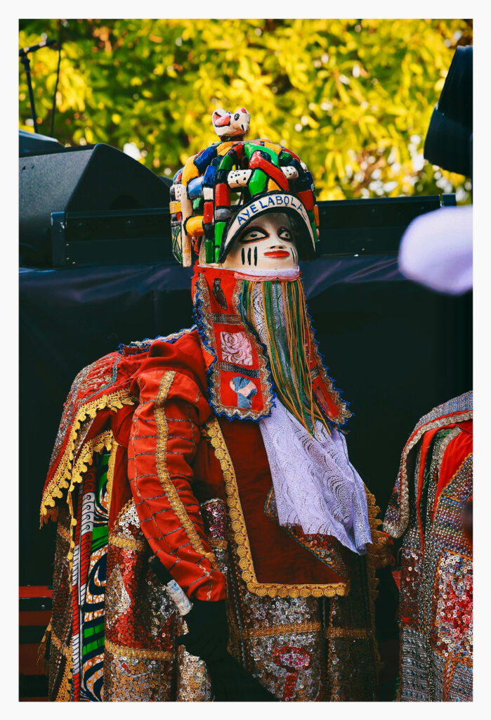 Masquerade figure standing and waiting between performances