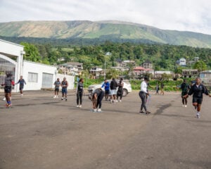 Vintage Run Club members warm up on a road in Buea, Mount Cameroon behind them — one of four African run clubs in this report.