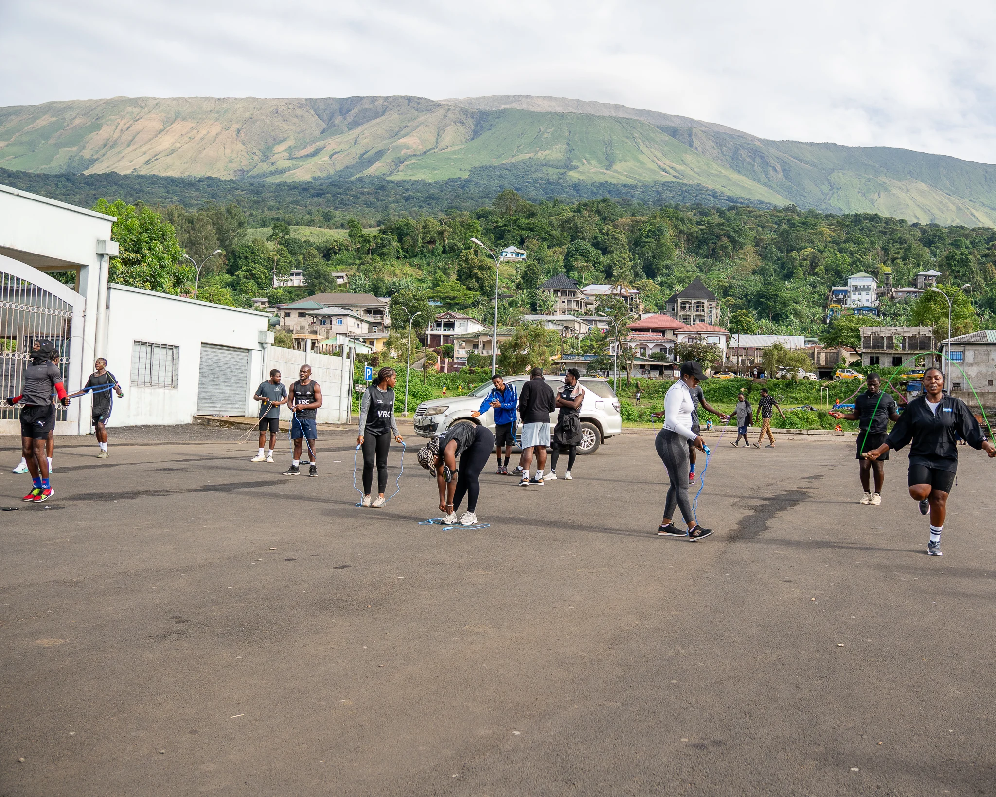 Vintage Run Club members warm up on a road in Buea, Mount Cameroon behind them — one of four African run clubs in this report.