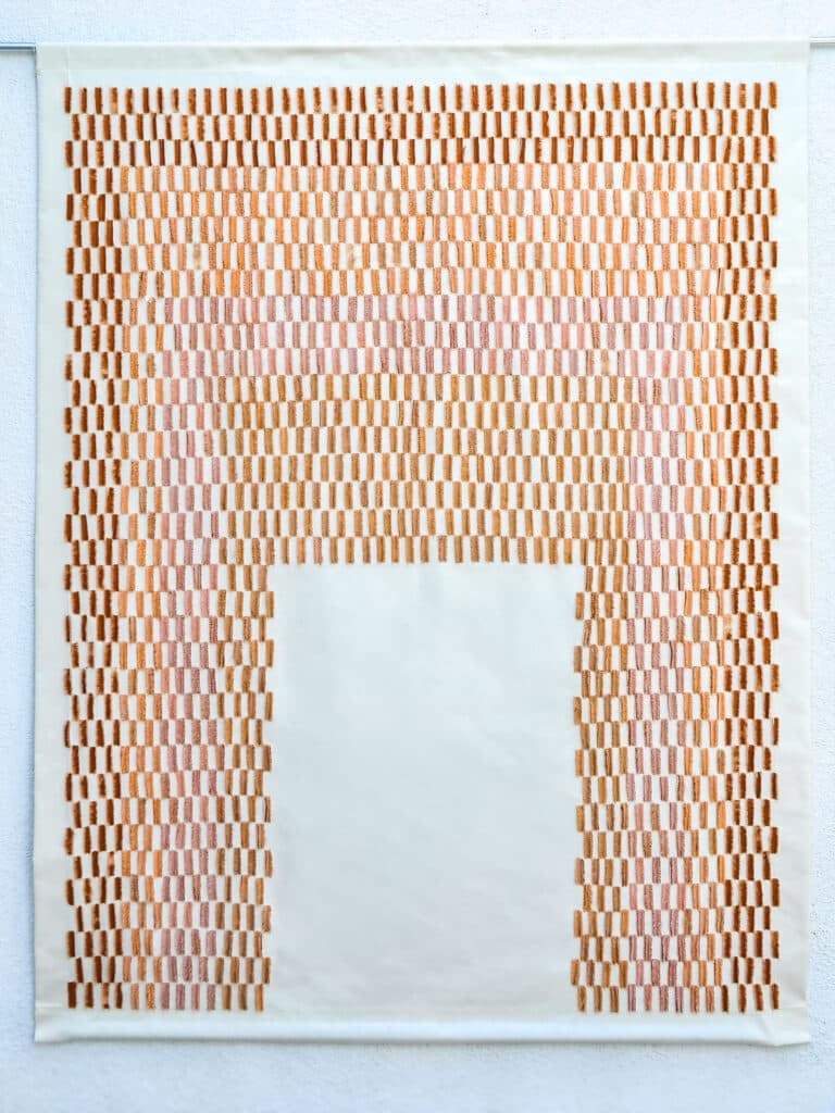 Bab, a wall-hung textile of dense vertical rust and ochre stitches on a pale ground, framing a plain pale panel in the shape of a doorway.