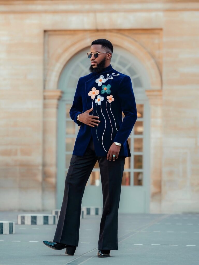 Akin Faminu on Style, Taste and the Things He Returns To 8 Akin Faminu in a navy floral-embroidered suit outside an arched Parisian building during Paris Fashion Week