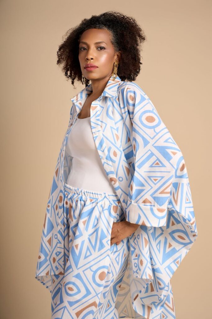 From Korhogo Cloth to Digital Print: Alia Baré and the Language of Senufo Textiles 7 Model in a pale blue and cream two-piece printed with a Hausa-derived geometric pattern, against a beige backdrop.