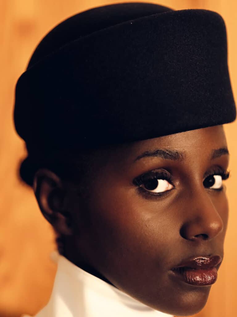 Warm-toned portrait of a woman in a black cap glancing over her shoulder
