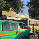 Commuters at a covered bus stop on a street in Lusaka.