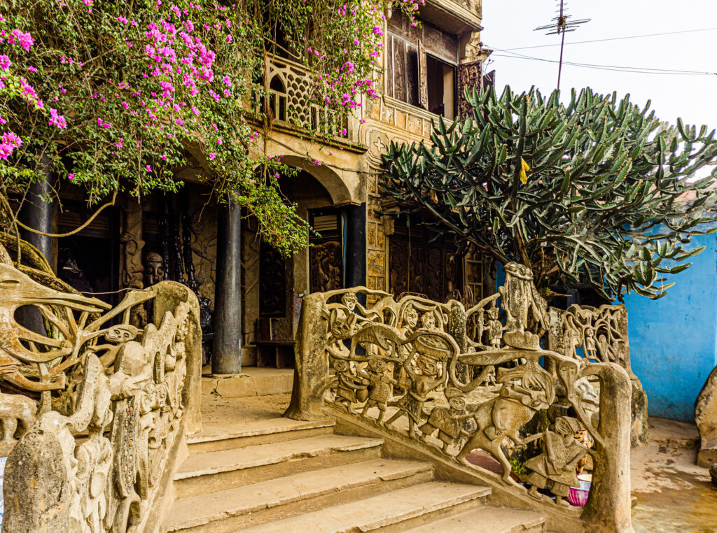 Exterior of Susanne Wenger's house with intricately carved cement screens and balustrades