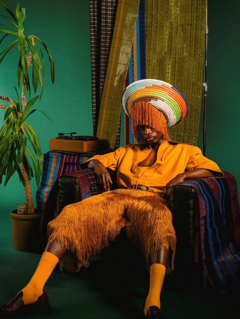 Holy One look with a layered multicoloured hat and fringed headwear