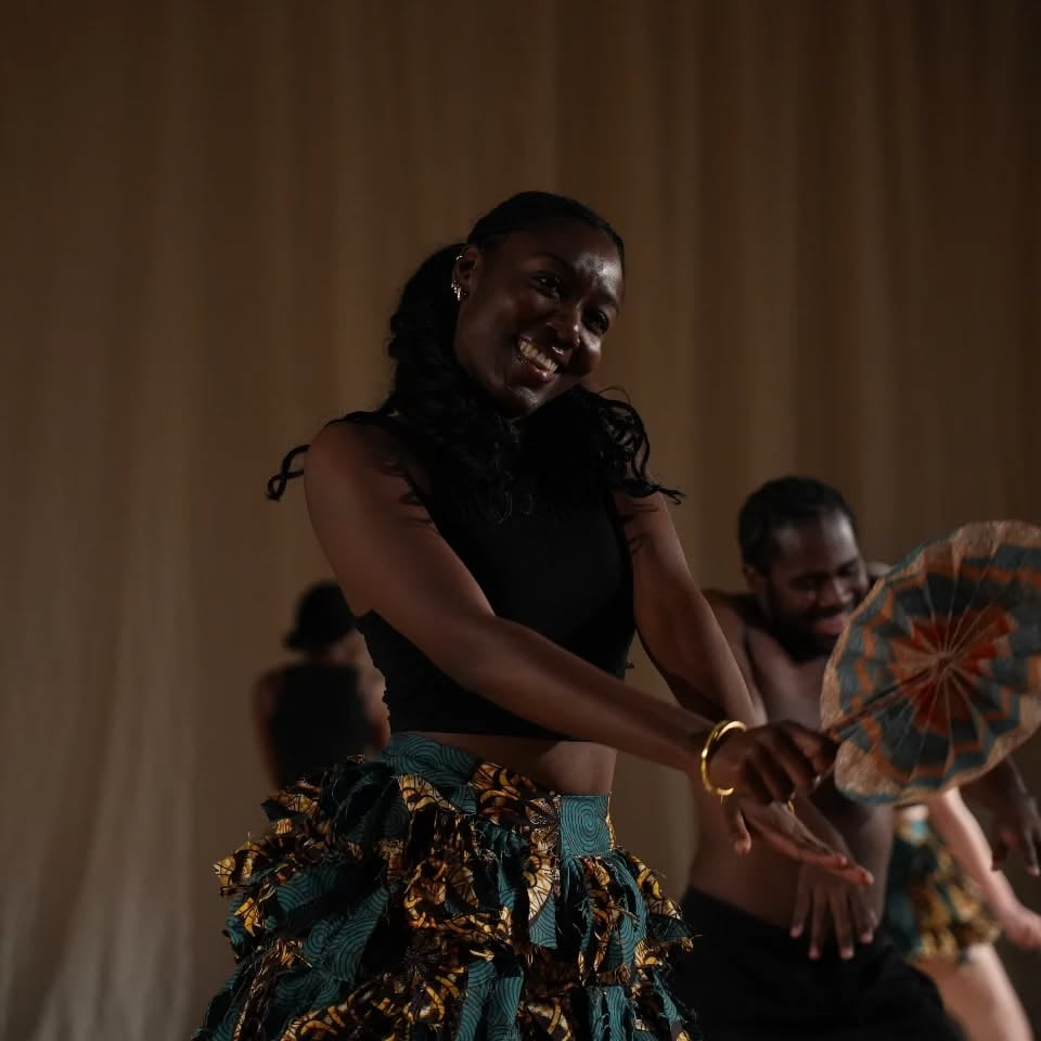 Omo Naija x Wahala Boys dancers perform in custom green and yellow print uniforms.