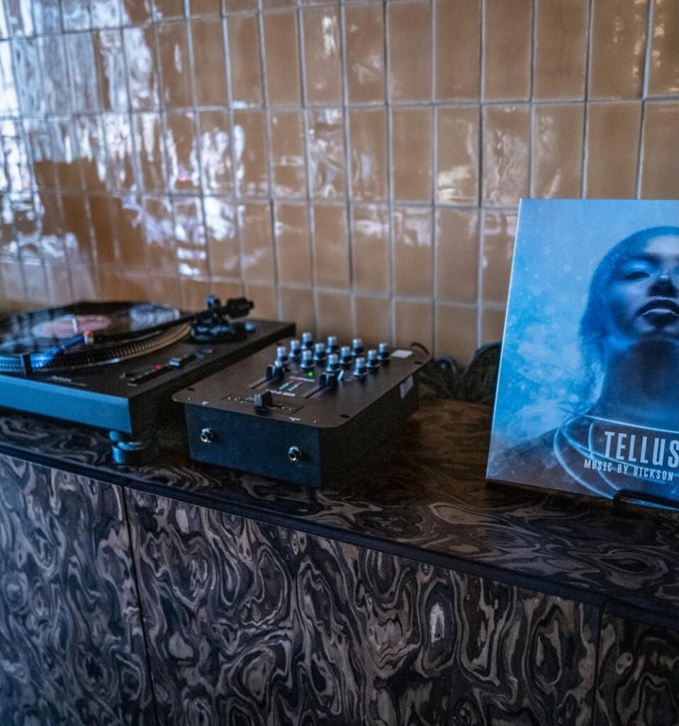 TELLUS vinyl sleeve beside a turntable and mixer at the album’s listening party at Mason & Fifth.