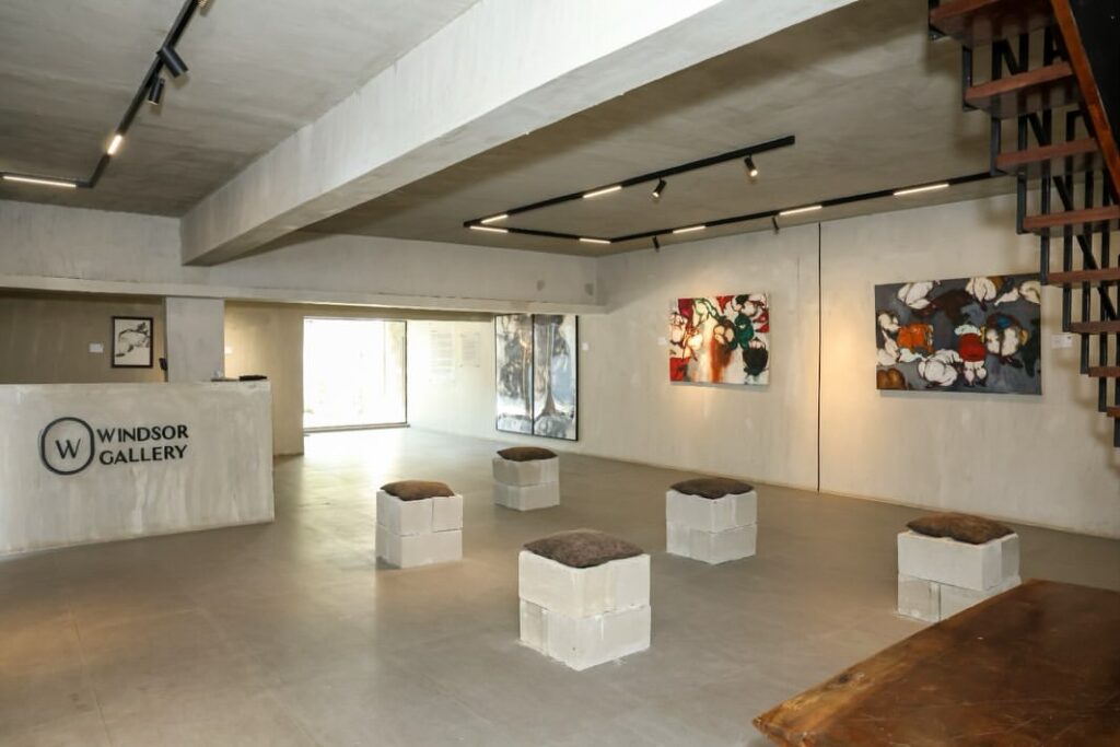 Concrete surfaces, paintings and low block seats on the ground floor of Windsor Gallery in Lagos, Nigeria.